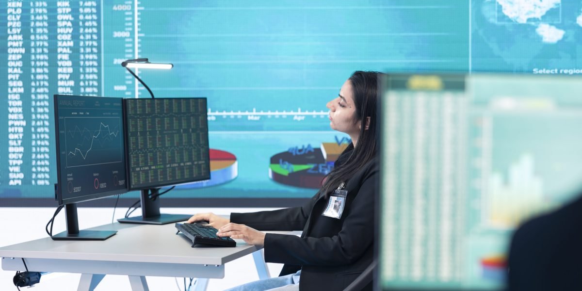 Enterprise analyst reviewing infographics numbers on a big screen at workstation, achieving strategic objectives in a competitive corporate environment. Employee improving efficiency.